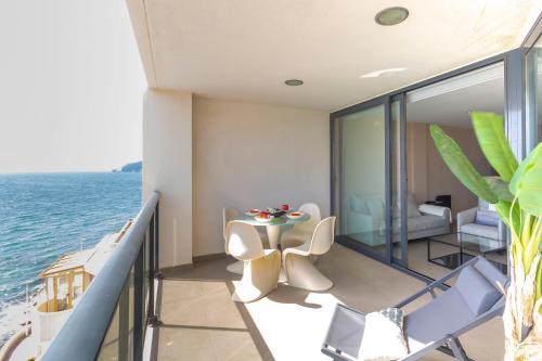 a balcony with a table and chairs and the ocean at Apartamento Bernia al Mar 8A by Costa CarpeDiem in Calpe
