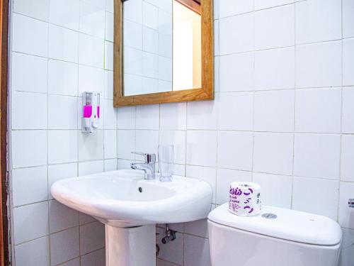 a bathroom with a sink and a toilet and a mirror at Explorers Hub in Kampala