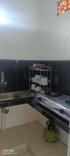 a black counter top with a shelf with towels at Lumbung Sari Home Stay in Amed