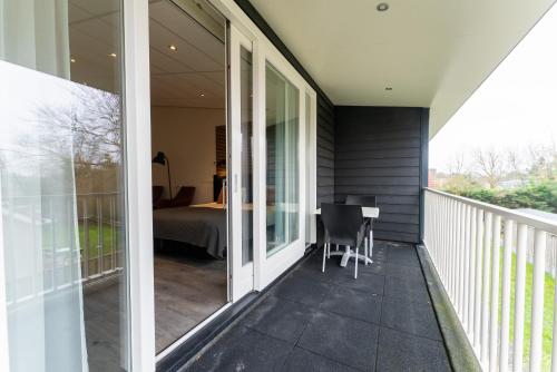 a screened porch with a bed and a bedroom at De Berkenhof in Nes
