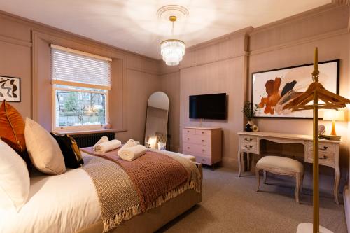 a bedroom with a bed and a desk and a television at Calming Crescent in Buxton