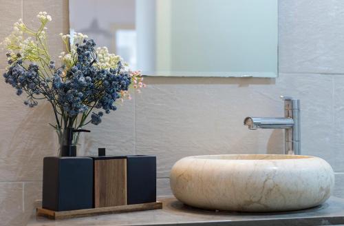 baño con lavabo y jarrón de flores en Centrico Tranquilo 2 Rooms, en Jerez de la Frontera