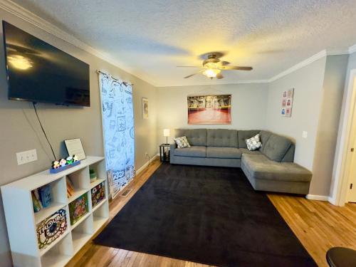 ein Wohnzimmer mit einem Sofa und einem TV in der Unterkunft Homey Townhouse Near Lake & Sports Complex in Guntersville
