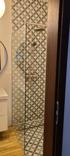 a shower with a glass door in a bathroom at Lovely One-Bedroom Condo With Patio. in Warsaw