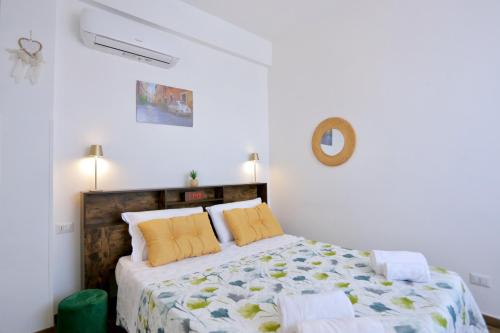 Dormitorio blanco con cama con almohadas amarillas en B&b Apartment Roma Centre, en Roma