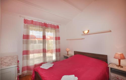 サン・シプリアン・プラージュにあるBeautiful Home In Saint Cyprien Plage With 3 Bedrooms And Wifiのベッドルーム1室(赤いベッド1台、窓付)