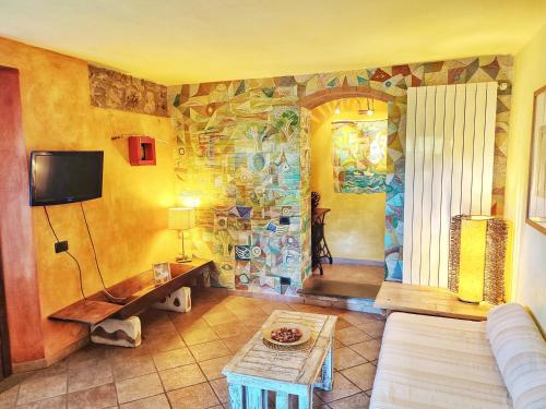 蒙帖斯庫達祐的住宿－Agriturismo Podere Santa Rita，客厅配有沙发和带壁画的墙壁