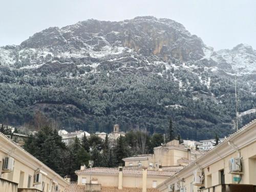 a mountain covered in snow in front of buildings at Cazorla LIVE in Cazorla
