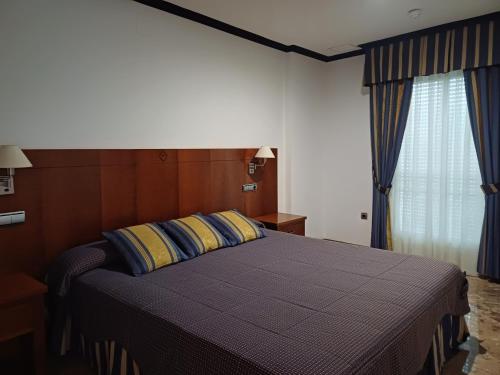 1 dormitorio con 1 cama con almohadas azules y amarillas en Cazorla LIVE, en Cazorla