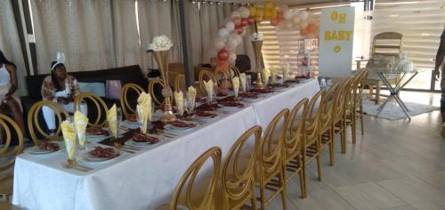 uma mesa longa com cadeiras e comida em elim glamour hotel em Elim