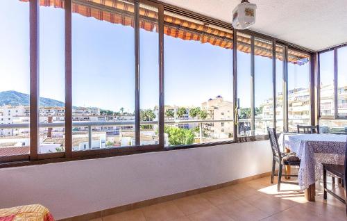 a room with large windows with a table and chairs at 1 Bedroom Amazing Apartment In Altea in Altea