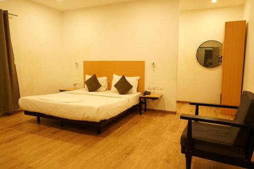 a bedroom with a large bed and a mirror at TREETOP INN in Chennai