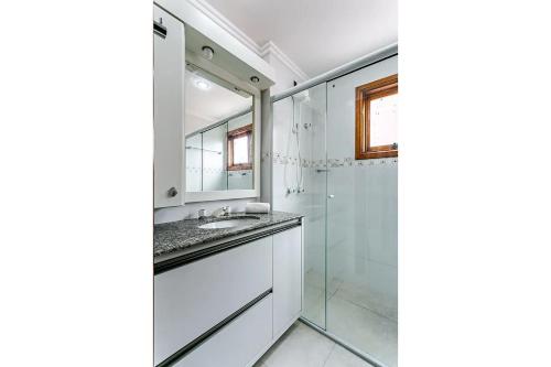 La salle de bains est pourvue d'une douche en verre et d'un lavabo. dans l'établissement Apto com duas suítes no Open Shopping CPJ304, à Florianópolis