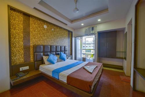 um quarto com uma cama grande e almofadas azuis em Hotel City Crown, Kolhapur 200 Mts from Bus Stand em Colhapur