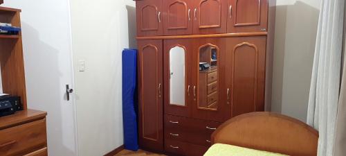 une grande armoire en bois dans une chambre avec un lit dans l'établissement Pousada e Hostel Sossego, à Luminárias