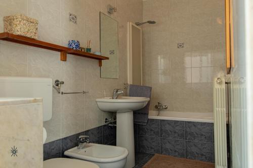 a bathroom with a sink and a toilet and a tub at Rooftop Madreperla in Taranto