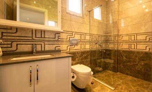 a bathroom with a toilet and a sink and a shower at Villa Eslem in Kas