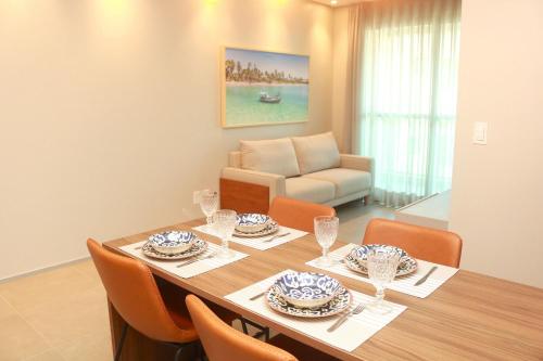 - une salle à manger avec une table, des chaises et un canapé dans l'établissement Edificio Liv P.Verde Apto 1014-Mandi Hospitalidade, à Maceió