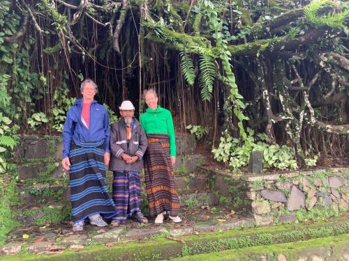 a group of three people standing in front of a tree at FARILA LODGE in Kelimutu