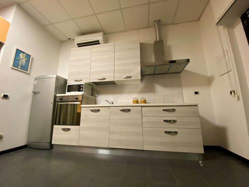  La cuisine est équipée de placards blancs et d'un réfrigérateur. dans l'établissement Pretty apartment next to Chianti and Florence, à Tavarnuzze
