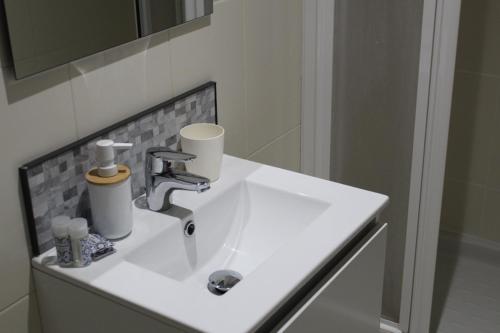 Un lavabo blanco con dos tazas. en Bahía de Montecarlo en Alcanar