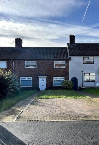 a brick house with a driveway in front of it at Cleveland View in Stockton-on-Tees