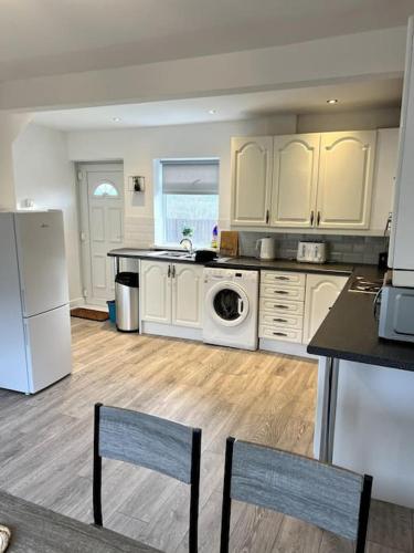 a kitchen with white cabinets and a washer and dryer at Cleveland View in Stockton-on-Tees