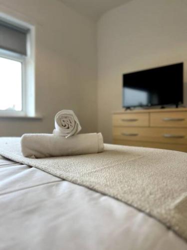 a towel sitting on top of a bed with a television at Cleveland View in Stockton-on-Tees