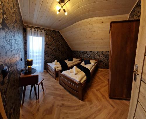 Zimmer mit Sofas und einem Tisch in einem Zimmer in der Unterkunft Domki 4 pory roku in Koniaków
