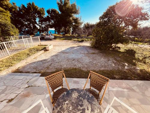 un par de sillas sentadas sobre una mesa en Beachfront apartment Drazen, with garden en Split
