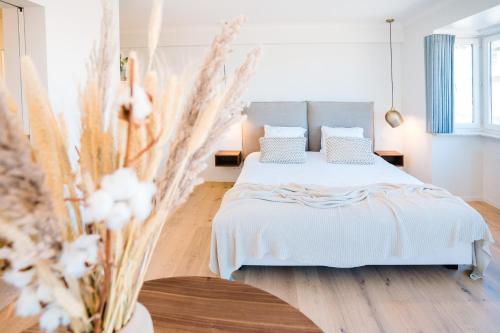 a bedroom with a bed with white sheets and pillows at Hotel du Bassin in Ostend