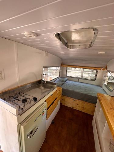 a kitchen with a stove and a sink in an rv at Glamping Playa Mansa in Mina Clavero