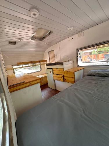 Ein Wohnmobil mit einem Bett und einem Fenster in der Unterkunft Glamping Playa Mansa in Mina Clavero