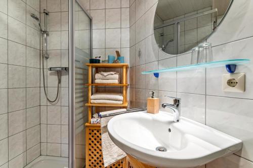 y baño blanco con lavabo y ducha. en Ferienwohnung Brandenkopf, en Oberharmersbach