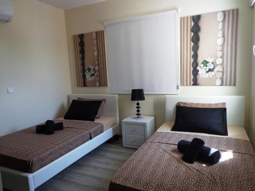 1 dormitorio con 2 camas con almohadas negras en Kyma 3 Bed Villa + Pool en Yeroskipou