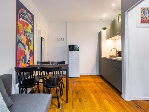 une cuisine et une salle à manger avec une table et des chaises dans l'établissement Le Repère de Copernic, à Nancy