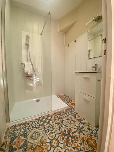 La salle de bains est pourvue d'une douche et de carrelage. dans l'établissement Le Moulin de César, à Vaison-la-Romaine