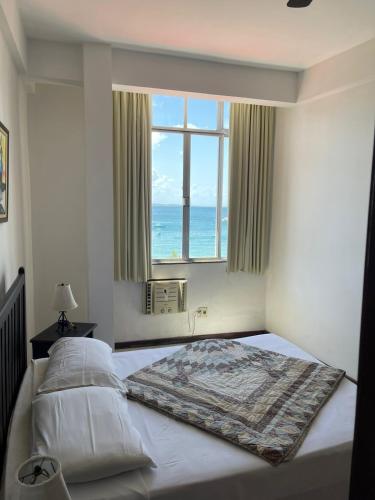 Un dormitorio con una cama con vista al mar. en Manga Rosa Suites, en Salvador