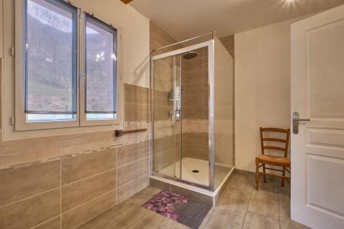 a shower in a bathroom with a window and a chair at le bien-être de la nature in Séchilienne