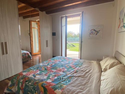 a bedroom with a bed with a colorful quilt on it at The Flowers - Apartments with Private Garden in Residence with Pool in Manerba del Garda