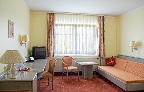 a hotel room with a couch and a table and a window at Hotel Borger in Frankfurt