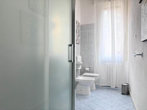 uma casa de banho com um WC e uma porta de duche em vidro. em Casa Sibilla em Ferrara