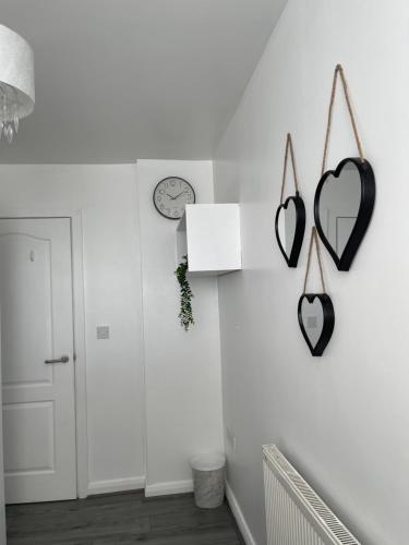 a hallway with two hearts on the wall and a clock at City Centre Luxury 2 Bed Apartment Free Parking in Liverpool