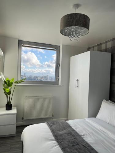 um quarto com uma cama branca e uma janela em City Centre Luxury 2 Bed Apartment Free Parking em Liverpool