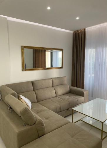 a living room with a couch and a glass table at Vini Apartments in Zagrađe