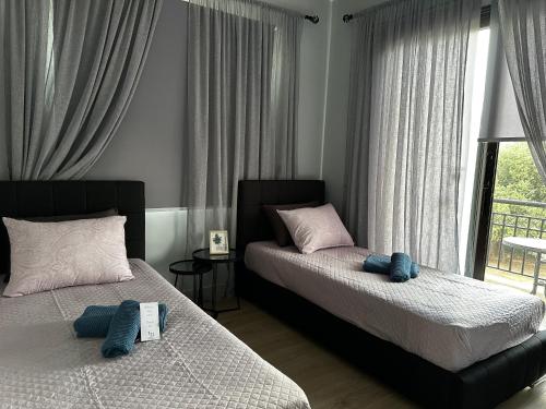 Un dormitorio con dos camas y una ventana. en Faros Beach sea view apart, en Pafos