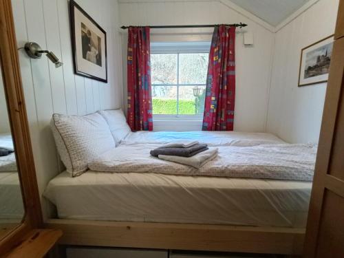 Bett in einem Zimmer mit Fenster in der Unterkunft Guest house close to Kristiansand in Kristiansand