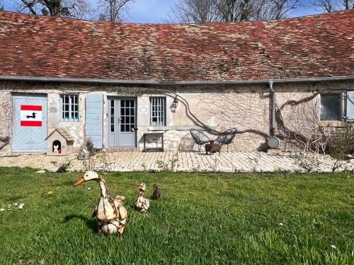 three rubber ducks in the grass in front of a house at La Forge de Malpas in Quingey