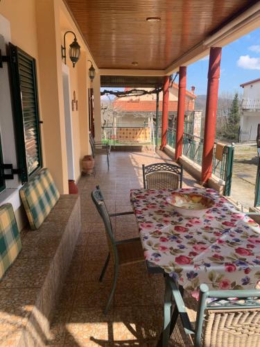 a table and chairs on the porch of a house at Lake Stories in Koutsodímos