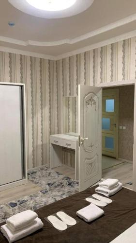 een badkamer met een wastafel en 4 witte handdoeken bij Trail Hotel in Tasjkent